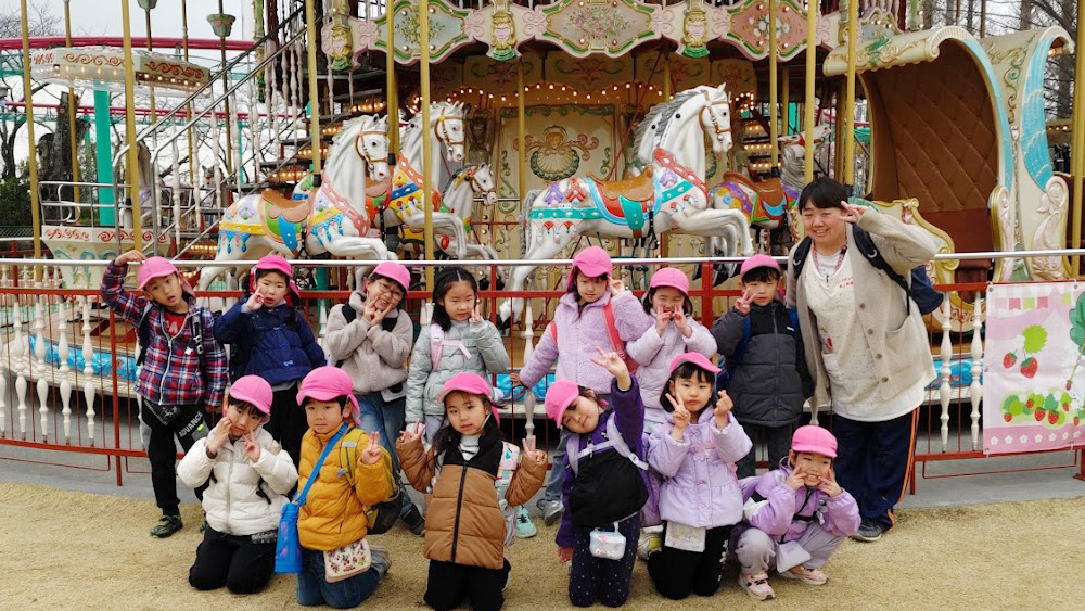 お別れ遠足　メリーゴーランドの前でポーズ